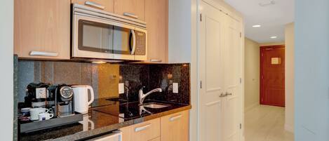 Cocina moderna con microondas integrado, cafetera y lavamanos.