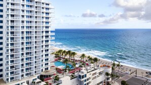 A high-rise hotel with a pool area, beach access, and ocean views.