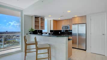 Una cocina moderna con una isla grande, electrodomésticos de acero inoxidable y vistas a la ciudad.