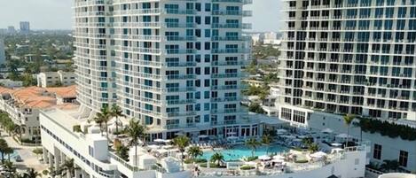 A high-rise hotel with multiple balconies and a rooftop pool area.