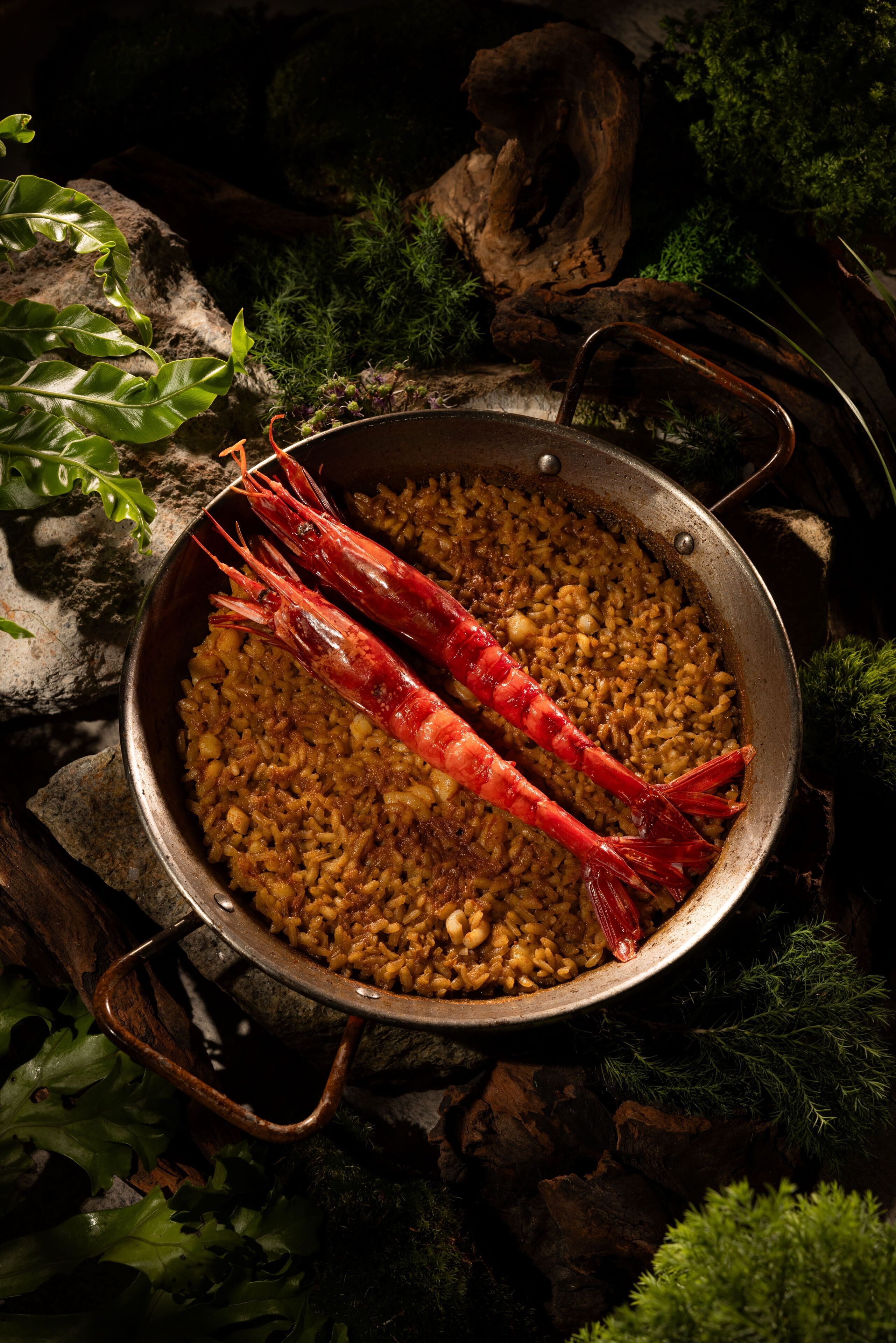 Una cazuela de arroz con dos camarones rojos.