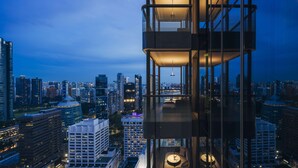 Um edifício alto com fachada de vidro e várias sacadas.