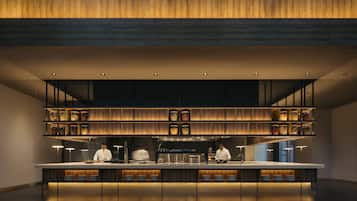 A modern kitchen with a central island, wooden shelves above, and a patterned floor.