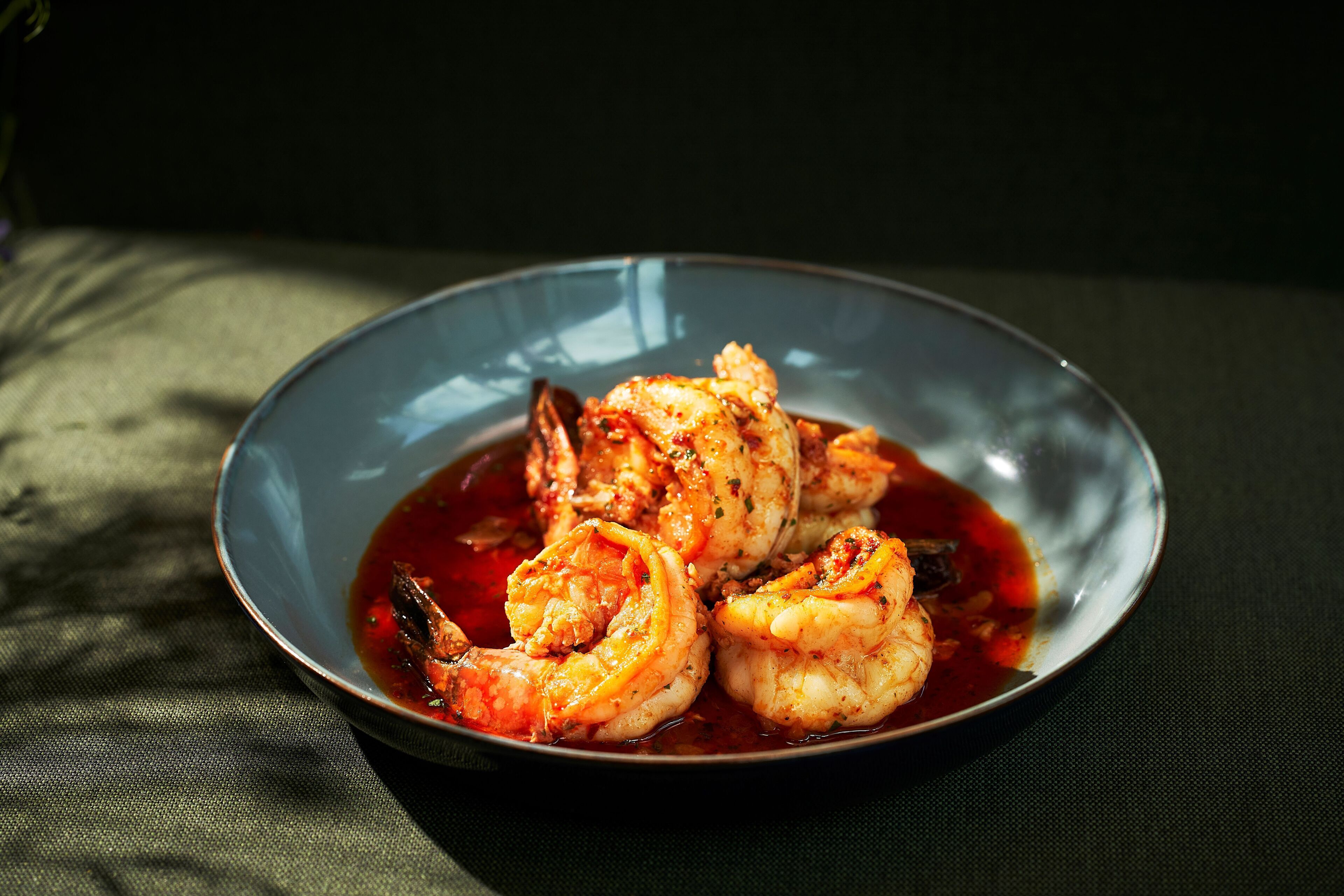 A bowl of shrimp in a sauce.