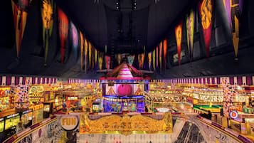 Ein lebhafter Spielsalon mit verschiedenen Spielautomaten und einer zentralen Bühne.