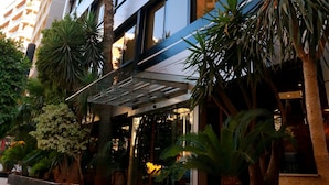 A modern building with multiple floors, large windows, and a covered outdoor area with plants. - Imperial Suites Hotel (Beirut)