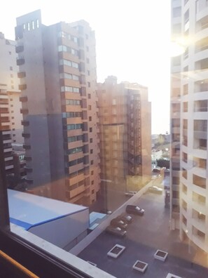 Vista de edificios residenciales altos con varios balcones y un estacionamiento al frente.