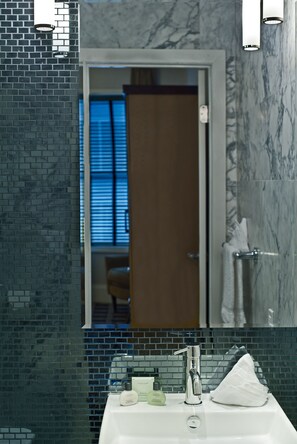 A bathroom with a mirror, a sink, and a towel rack. - Square Hotel at Times Square (New York)