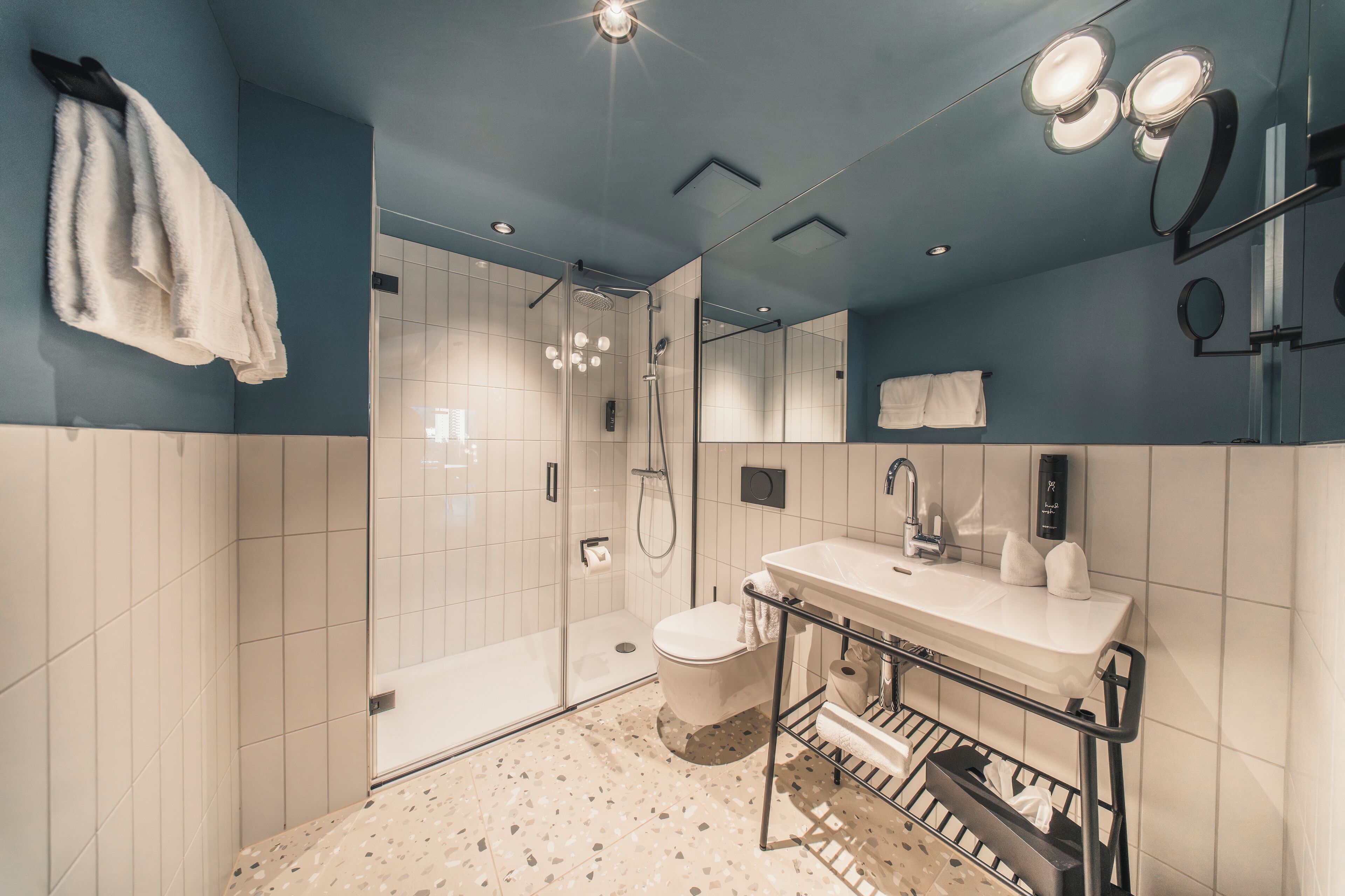 A modern bathroom with a shower, toilet, and sink.
