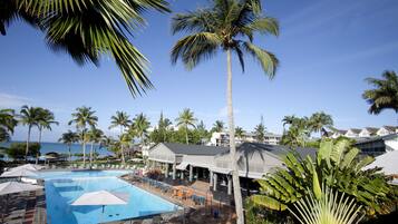 Una piscina al aire libre, sombrillas, tumbonas