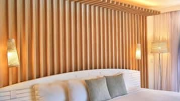 Une chambre d’hôtel avec un grand lit, un mur lambrissé en bois et deux lampes fixées au mur.