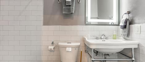 A bathroom with a toilet, sink, and towel rack.
