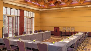 A conference room with a long table, chairs, and a podium.