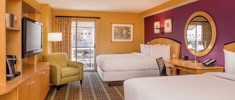 A hotel room with two beds, a TV, a desk with a phone, a chair, and a view of the outside.