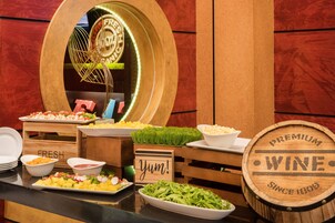A buffet table with various food items and a wooden barrel labeled "PREMIUM WINE SINCE 1809".