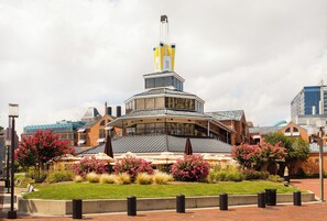 A hotel with a distinctive tower, outdoor seating, and a landscaped garden.