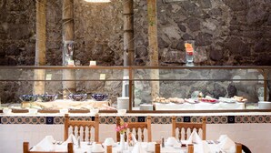 Un espace buffet agrémenté d’un mur en pierre servant de décor, proposant une variété de plats, et doté d’un mur recouvert de carreaux.