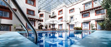 Una piscina al aire libre, sombrillas