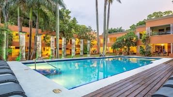 Una piscina al aire libre, sillones reclinables de piscina