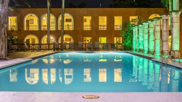 Una piscina al aire libre, sillones reclinables de piscina