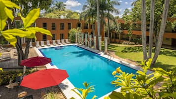 Una piscina al aire libre, sillones reclinables de piscina