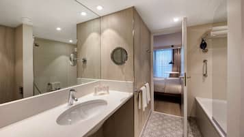Une salle de bain moderne avec un grand lavabo, un miroir et une douche à l’italienne.