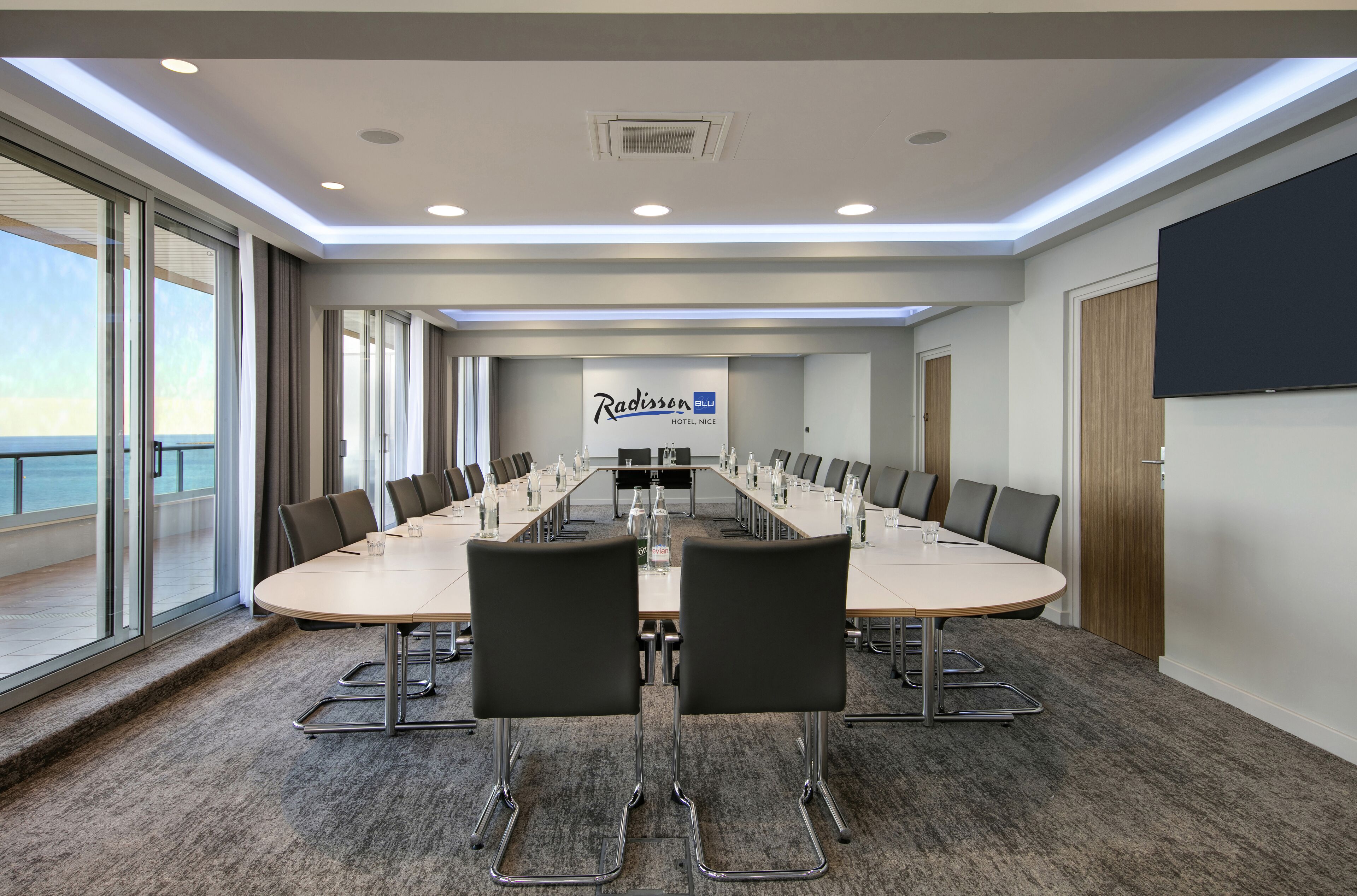 A conference room with a long table, chairs, and a Radisson Blu sign.
