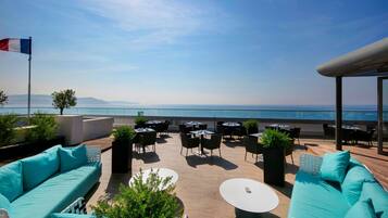 Enjoy breathtaking sea views from this rooftop terrace, featuring comfortable seating and lush greenery.