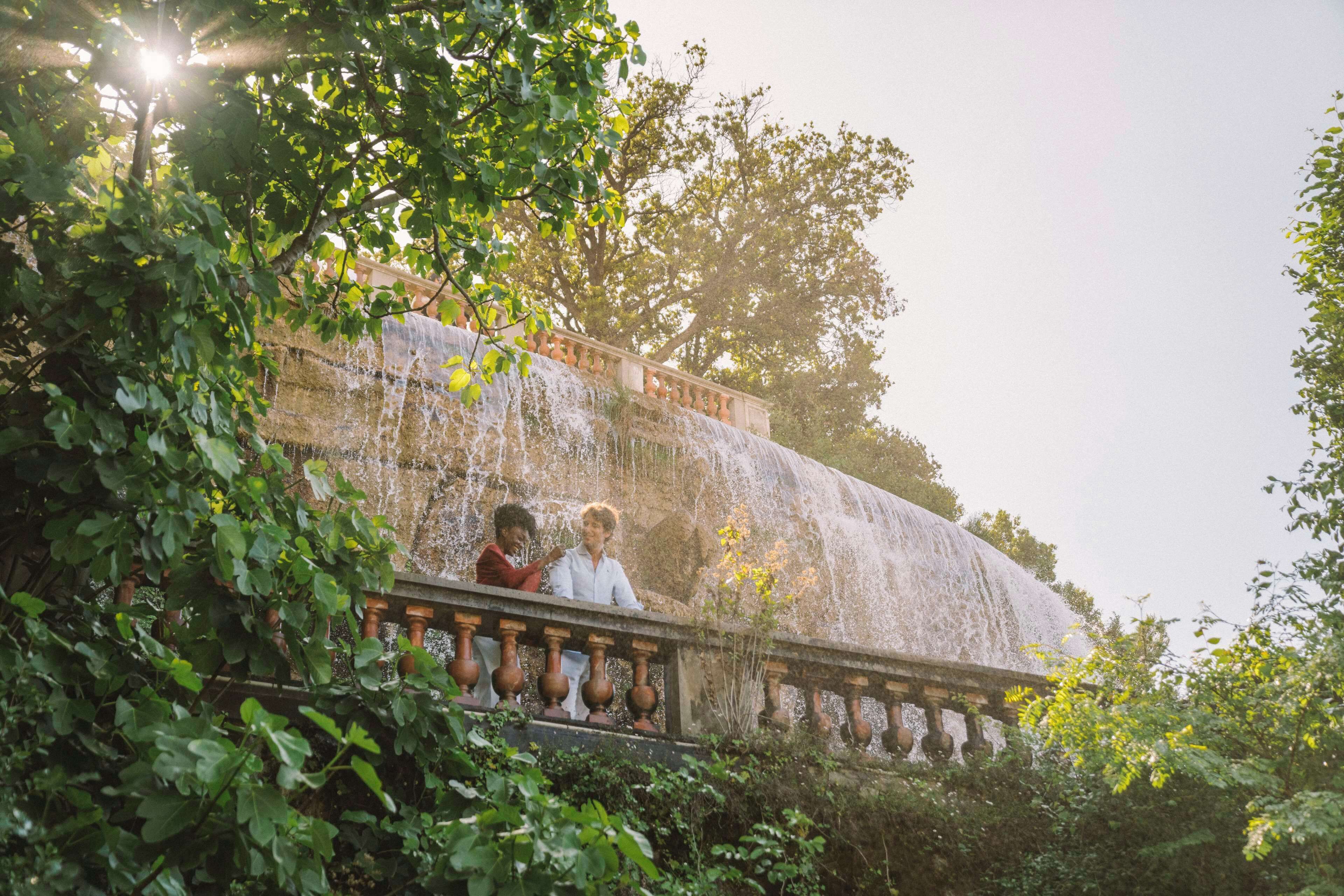 A stone balustrade with a waterfall cascading down a terraced structure.