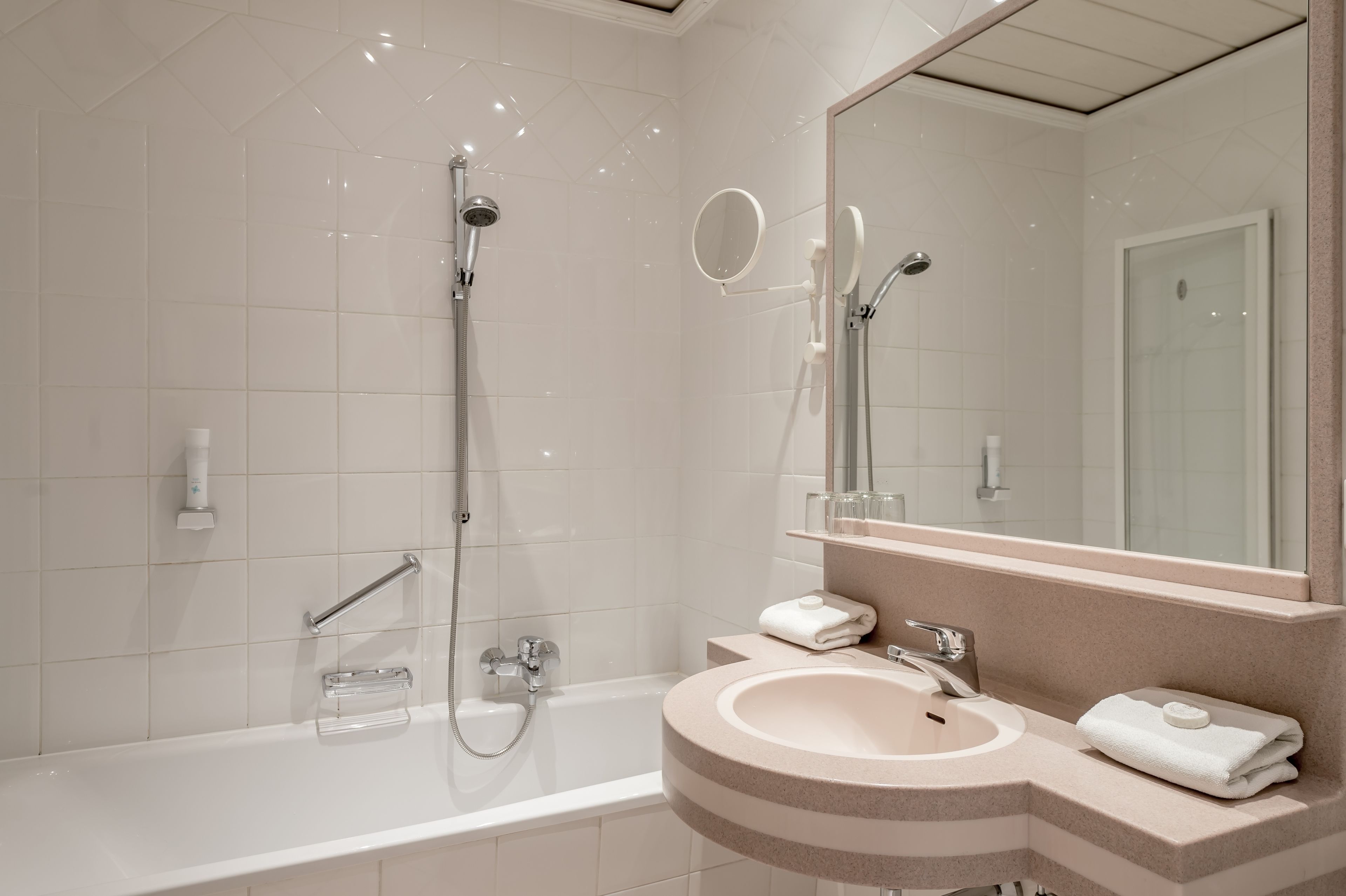 A modern bathroom with a bathtub, a sink, and a large mirror.