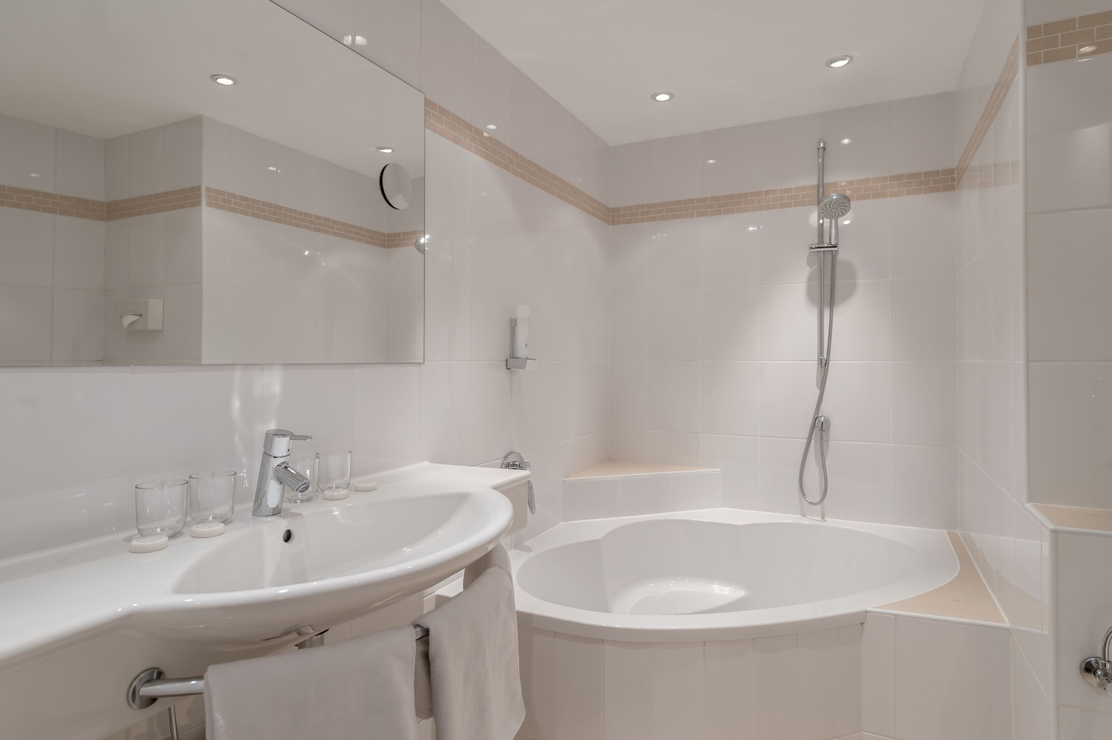 Une salle de bain moderne avec deux lavabos, une grande baignoire et une douche.
