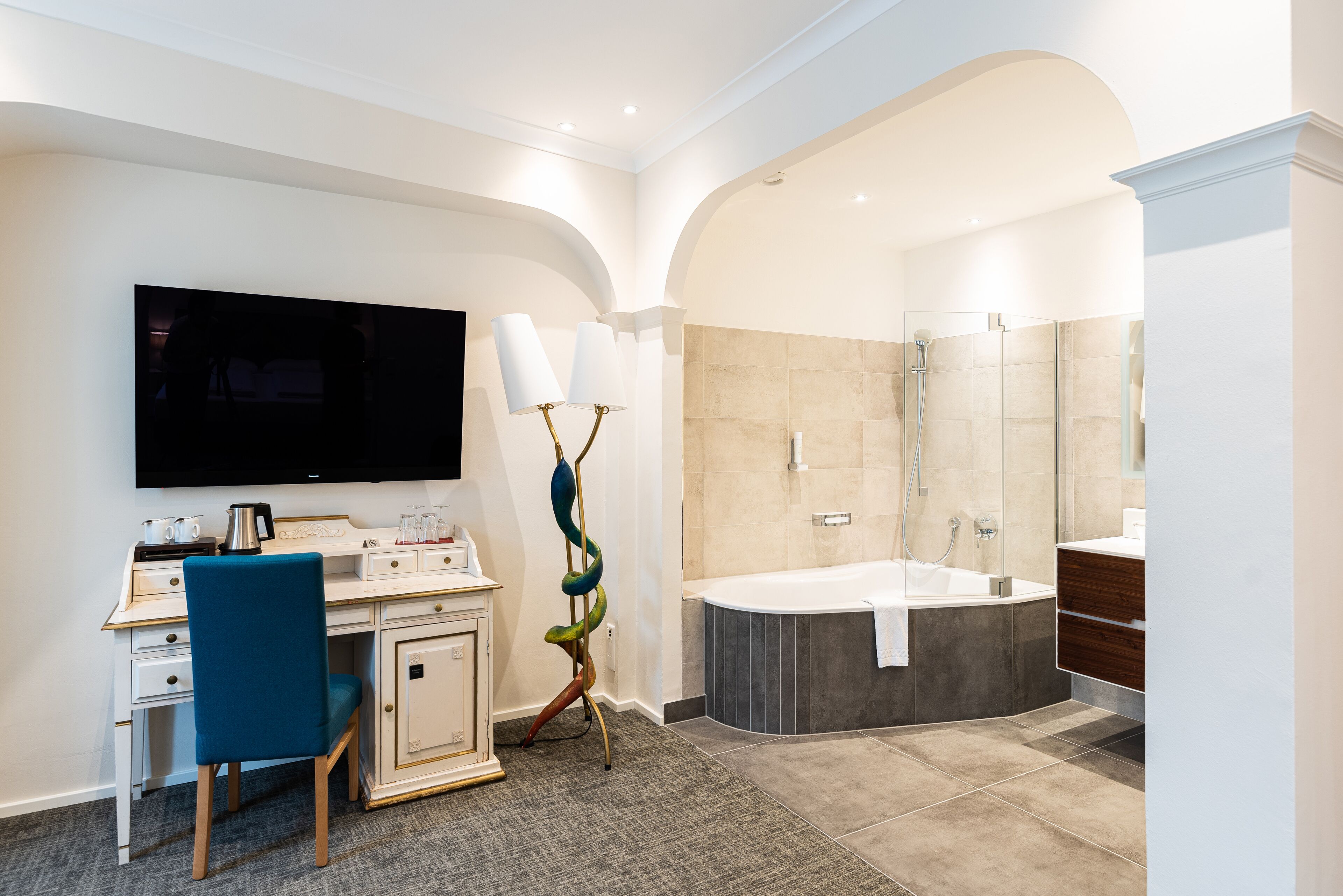 Een moderne badkamer met een bad, douche en wastafel.