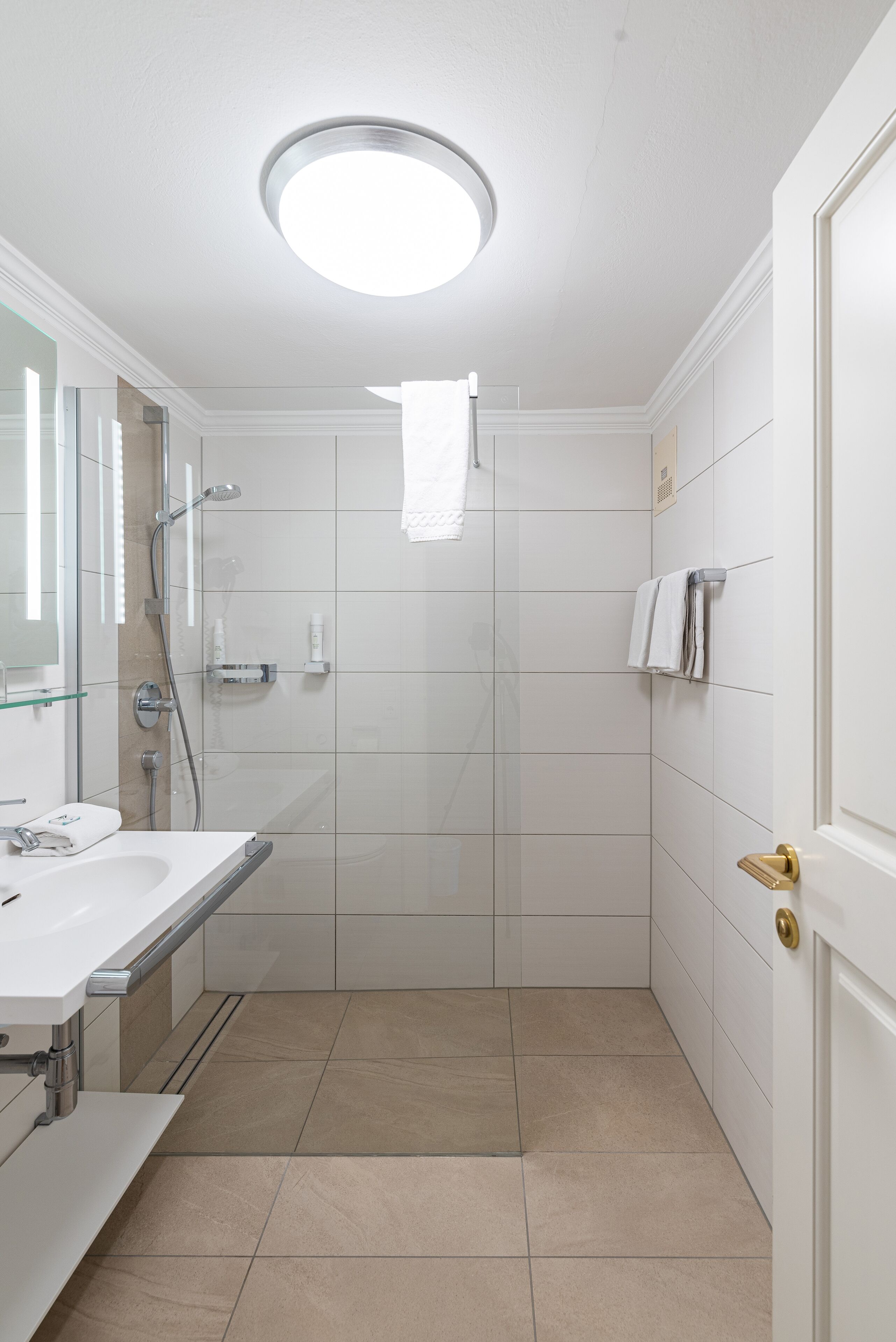 Une salle de bain moderne équipée d’une douche, d’un lavabo et de toilettes.