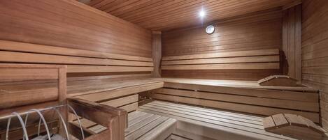 A sauna with wooden benches and a clock on the wall.