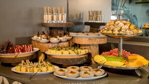 A buffet with various food items including cakes, pastries, and fruits.