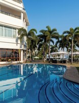 Una piscina al aire libre, sombrillas, sillones reclinables de piscina