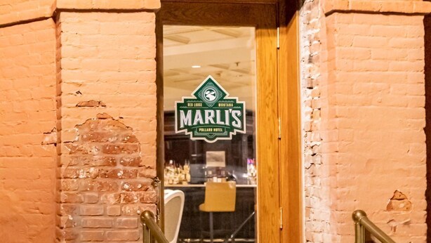 A hotel entrance with a wooden door and a sign that reads "Marl's Pollard Hotel".