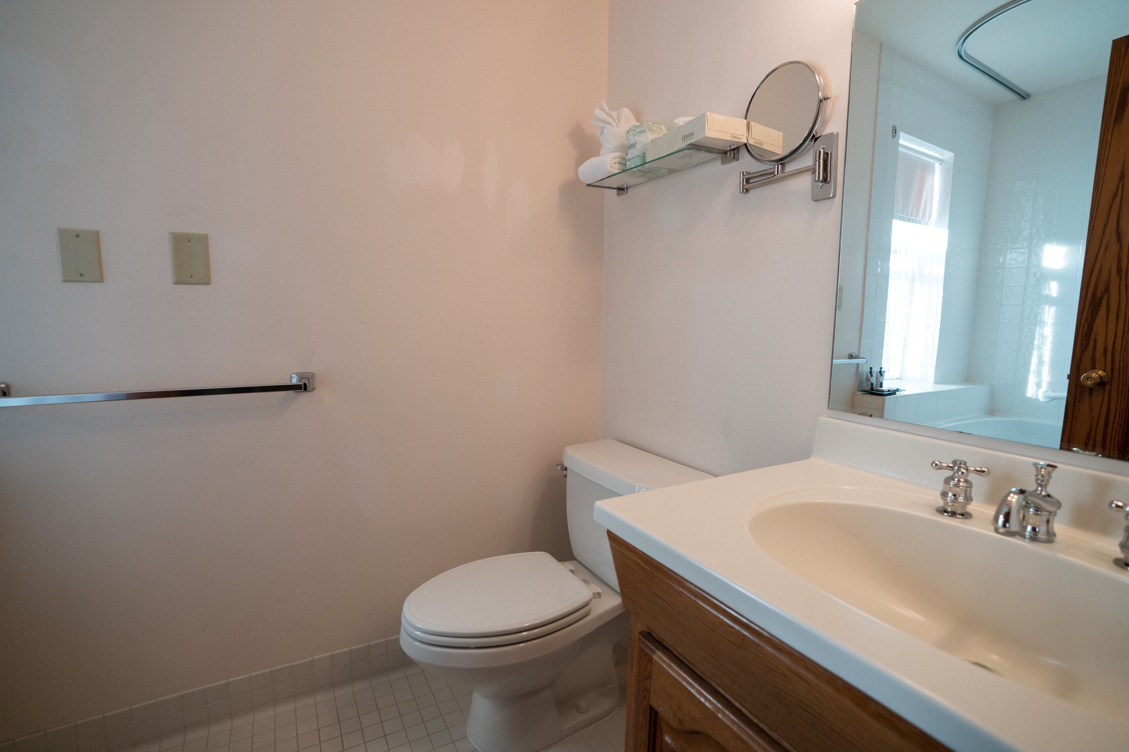 Une salle de bain avec des toilettes, un lavabo et un miroir.