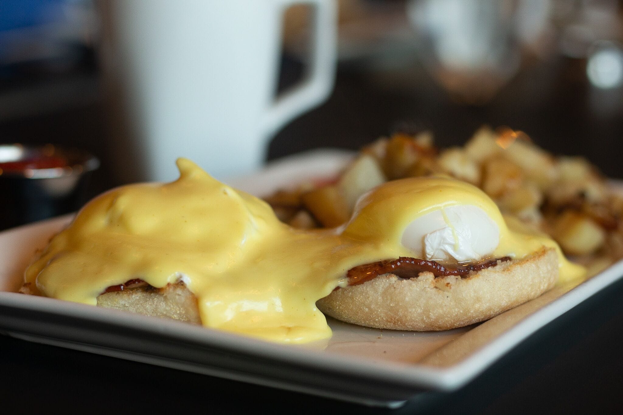 A plate of eggs benedict with hollandaise sauce.