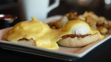 En tallerken med eggs benedict og hollandaisesauce.