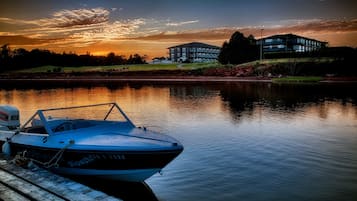 Un barco atracado en un muelle de madera con un edificio al fondo.