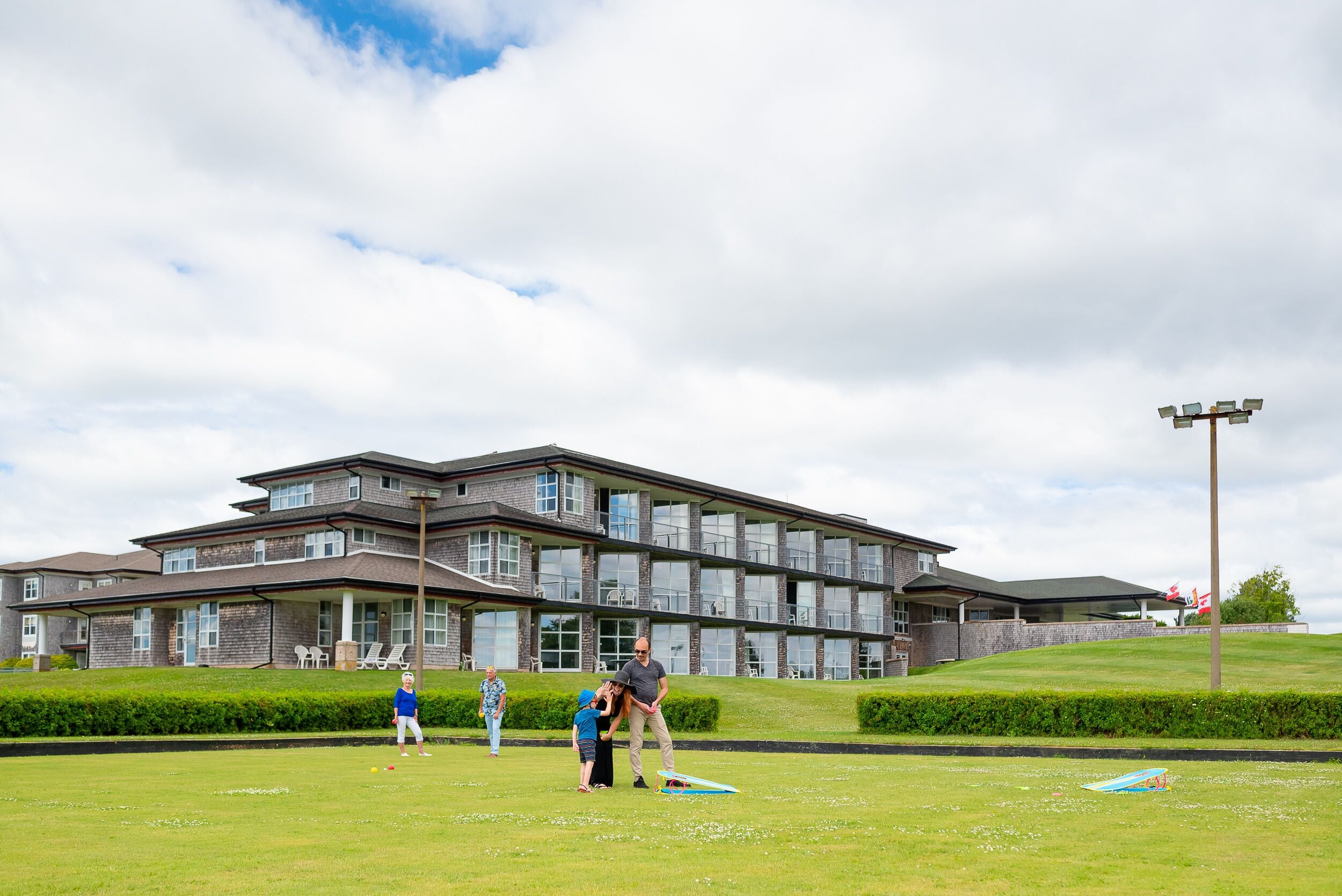 A modern building with a flat roof, large windows, and a well-maintained lawn.