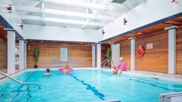 Una piscina interior con paredes de madera y un techo alto.