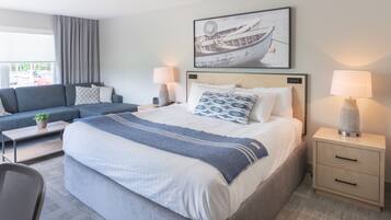 Une chambre d’hôtel moderne avec un grand lit, un canapé, un bureau et une lampe.