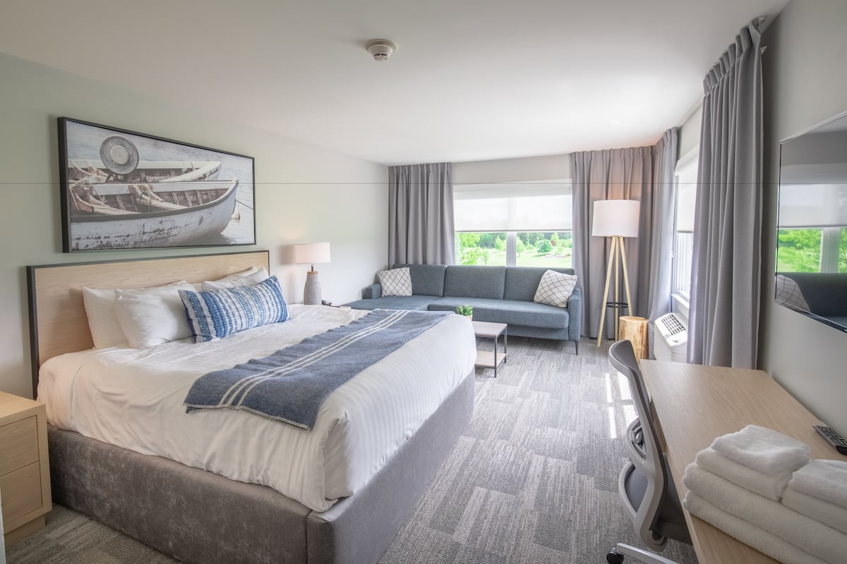 Une chambre d’hôtel moderne équipée d’un grand lit, d’un canapé, d’un bureau et d’une télévision.