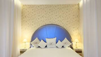 A hotel room with a large bed, a decorative headboard, and two bedside tables with lamps.