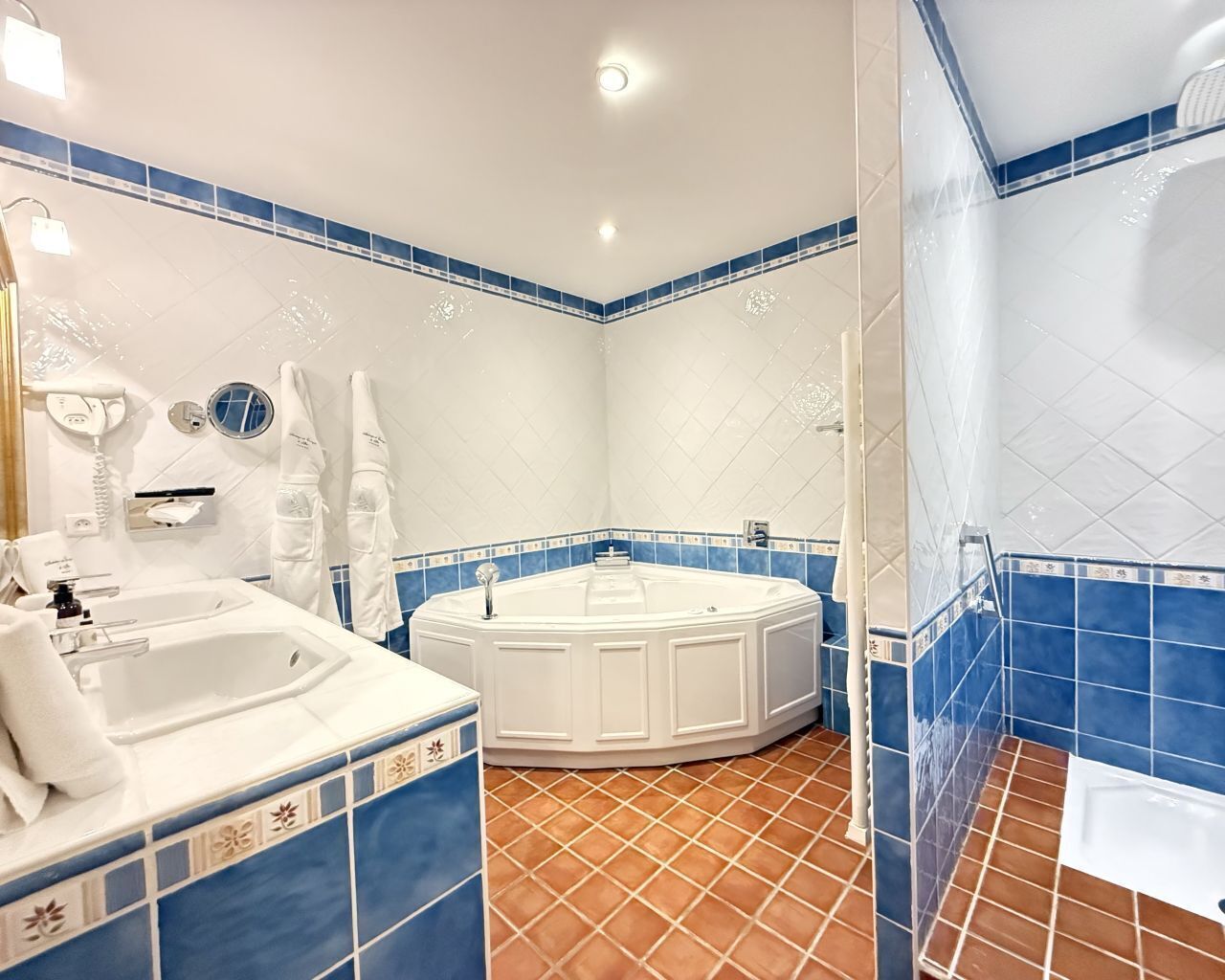 Un baño con bañera, ducha separada y tocador con lavamanos.