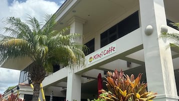 A building with a sign reading "Kihei Caffe" and a palm tree in front.