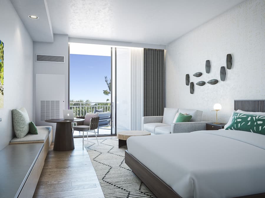 A modern hotel room with a large bed, a desk with a laptop, a balcony with outdoor seating, and a large painting of a beach scene.