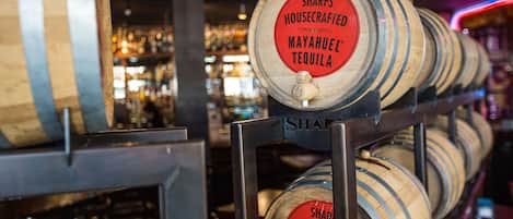 A rack of wooden barrels labeled "SHARPS HOUSECRAFTED MAYAHUEL TEQUILA".